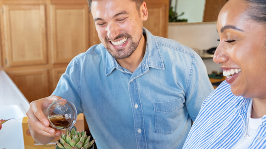 Two people laughing doing plant care with We The Wild